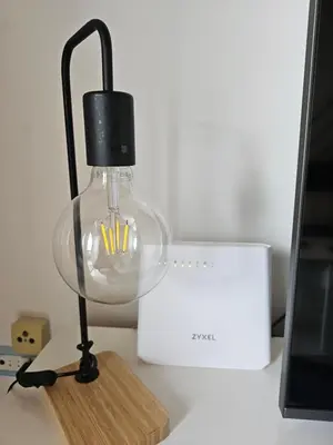 a glass lamp with a wooden base on a desk at Soleil Beach House in Santa Maria