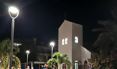 a clock tower at night with people walking in front at Soleil Beach House in Santa Maria