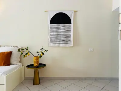 a bedroom with a window and a vase on a table at Wind Holiday Apartments - By Bobbywashere in Santa Maria