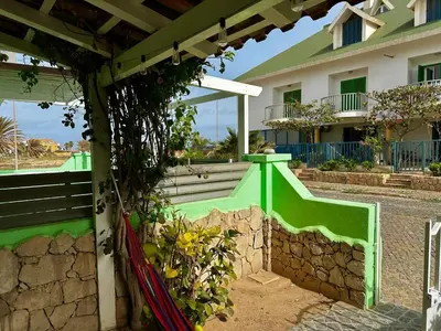 a green bench in front of a house at Wind Holiday Apartments - By Bobbywashere in Santa Maria