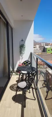 two chairs and a table on a balcony at chambre chez alcinda in Mindelo