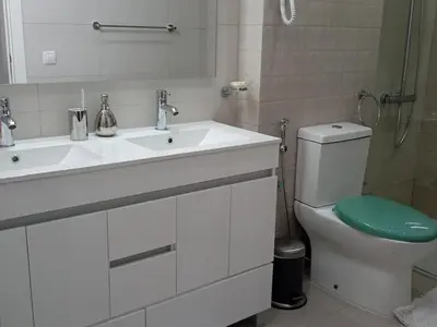 a white bathroom with a sink and a toilet at chambre chez alcinda in Mindelo