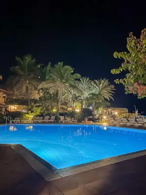 a large blue swimming pool at night with palm trees at Porto Antigo 2 - Apt 54 in Santa Maria