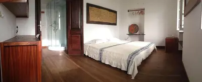 a bedroom with a bed and a glass door at Casa Café Mindelo in Mindelo