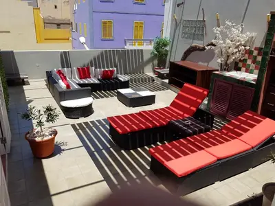 a patio with couches and chairs on a balcony at Casa Café Mindelo in Mindelo