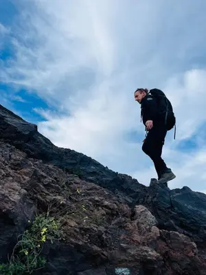 a man with a backpack standing on a rock at Casa Adriano & Filomena Montrond in Portela