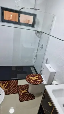 a bathroom with a toilet and a glass shower at SUITES-HOME, CIDADELA in Praia