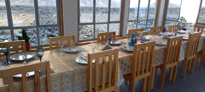 a dining room with a table and chairs and windows at Casa Adriano & Filomena in Portela