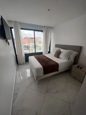 a bedroom with a bed and a large window at Residencial Santo Amaro in Tarrafal
