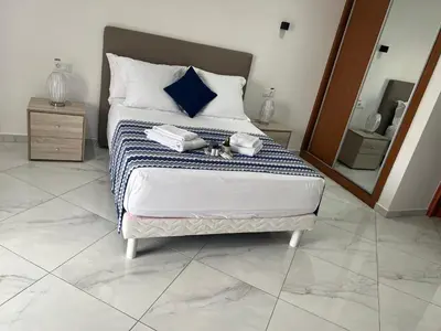 a bedroom with a bed with towels on it at Residencial Santo Amaro in Tarrafal