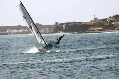 a person is windsurfing on the water with a sail at Casa Bahia 5 in Santa Maria