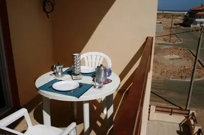 a small white table with chairs and plates on it at Casa Bahia 5 in Santa Maria