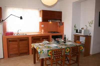 a kitchen with a table with chairs and a microwave at Casa Bahia 5 in Santa Maria