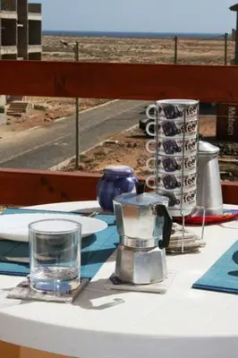 a table with a glass of water on top of it at Casa Bahia 8 in Santa Maria