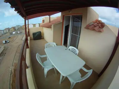 a table and chairs on a balcony with a view of a street at Casa Bahia 10 Grande Penthouse in Santa Maria