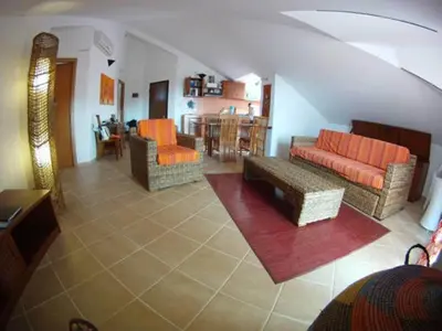 a living room with couches and chairs and a kitchen at Casa Bahia 10 Grande Penthouse in Santa Maria