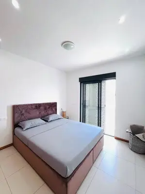 a bedroom with a large bed in a white room at Bliss Apartments T1 - Adélia in Mindelo