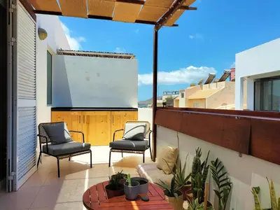 a balcony with two chairs and a large screen at Bliss Apartments T1 - Adélia in Mindelo