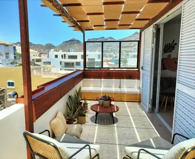 a balcony with a table and chairs on a house at Bliss Apartments T1 - Adélia in Mindelo