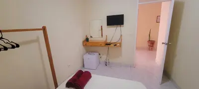 a room with a bed and a television on a wall at OpenSky in São Filipe