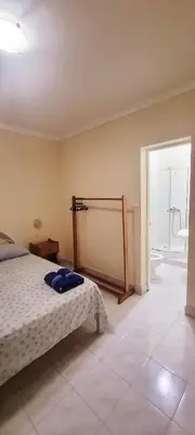 a bedroom with a bed and a bathroom with a shower at OpenSky in São Filipe