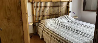 a bedroom with a bed with a wooden headboard at Apartamento Porto Antigo 2 in Santa Maria
