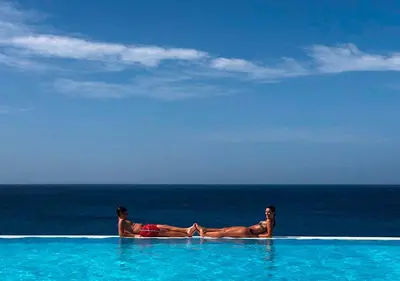 a man and woman laying in a swimming pool near the ocean at Appartamento BICA. Stella Maris Exclusive in Calheta Do Maio
