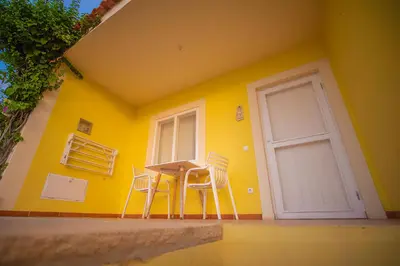 a yellow room with chairs and a table and a door at Appartamento LULA. Stella Maris Exclusive in Calheta Do Maio