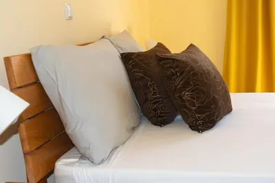 a bed with four pillows on top of it at Beauty Plaza Suites in Santa Maria