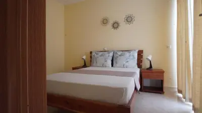 a bedroom with a bed and two clocks on the wall at Beauty Plaza Suites in Santa Maria