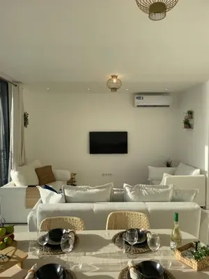 a living room with a white couch and a tv at Ocean View Santa Filomena in Mindelo