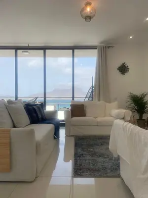 a living room with white couches and a view of the ocean at Ocean View Santa Filomena in Mindelo