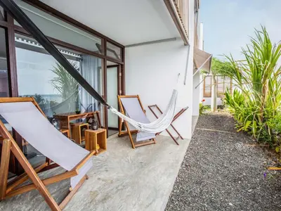 a hammock on the patio of a house at King Fisher Village Eco-Boutique Hotel in Tarrafal
