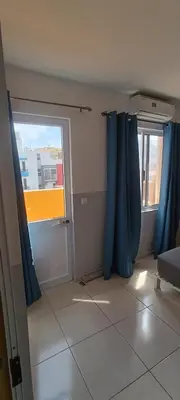 a room with blue curtains and a large window at Óscar in Mindelo