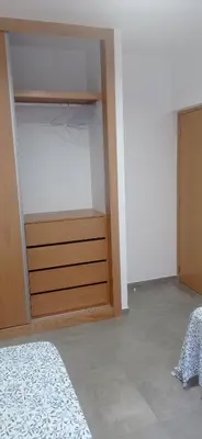 a bedroom with a bed and a wooden closet at Tity Apartments T2- Santa Maria in Santa Maria