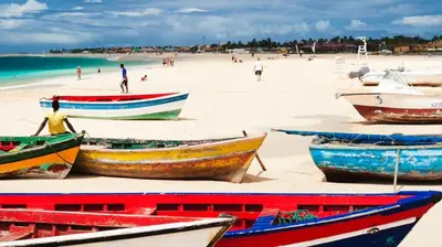 a group of boats on a beach with people on the beach at Tity Apartments T2- Santa Maria in Santa Maria