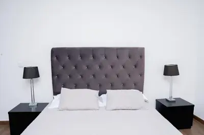 a bedroom with a large bed with two lamps at Villa Santiago in Praia