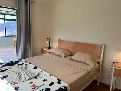 a bedroom with a bed with a blanket and pillows at Casa Manuel & Elvira in Chão Queimado