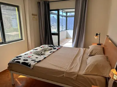 a bed in a bedroom with a large window at Casa Manuel & Elvira in Chão Queimado