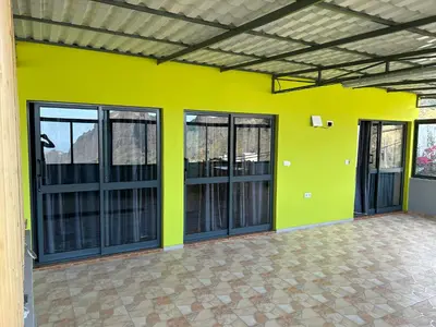 an empty room with a yellow wall and windows at Casa Manuel & Elvira in Chão Queimado
