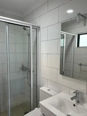 a bathroom with a shower and a sink and a mirror at Casa Manuel & Elvira in Chão Queimado