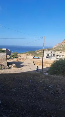 a person walking on a dirt road near the ocean at Casa Graciosa in Tarrafal