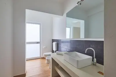 a white bathroom with a sink and a mirror at Branco Sea Holiday Apartments in Santa Maria