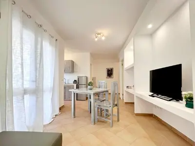 a living room with a table and a television at Branco Sea Holiday Apartments in Santa Maria