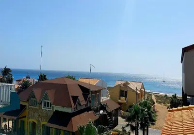 a group of houses on a beach with the ocean at Branco Sea Holiday Apartments in Santa Maria