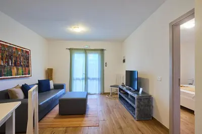 a living room with a couch and a tv at Branco Sea Holiday Apartments in Santa Maria