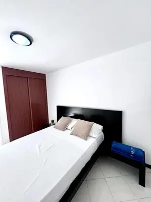 a bedroom with a large white bed with a black headboard at Bliss Apartments T3 - Zita - On The Beach in Mindelo