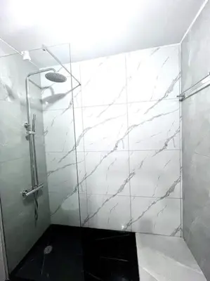a bathroom with a shower with a glass door at Bliss Apartments T3 - Zita - On The Beach in Mindelo