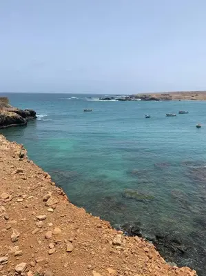 a large body of water with rocks and a beach at Modern Apartment in Praia Baixo - 1 min Walking to Beach in Praia Baixo