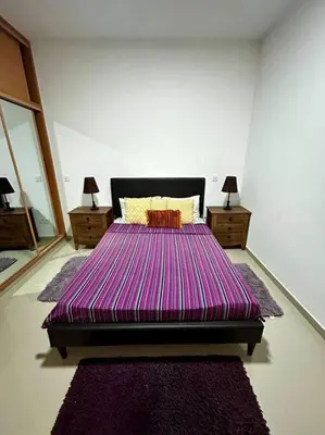 a bedroom with a large purple bed with two night stands at Modern Apartment in Praia Baixo - 1 min Walking to Beach in Praia Baixo